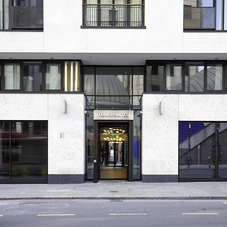 Tower Suites By Blue Orchid لندن المظهر الخارجي الصورة The image shows the entrance of a modern building, characterized by its minimalist architectural design. The facade features a combination of large glass windows and smooth stone surfaces. The entrance is framed by glass doors, flanked by stylish lig