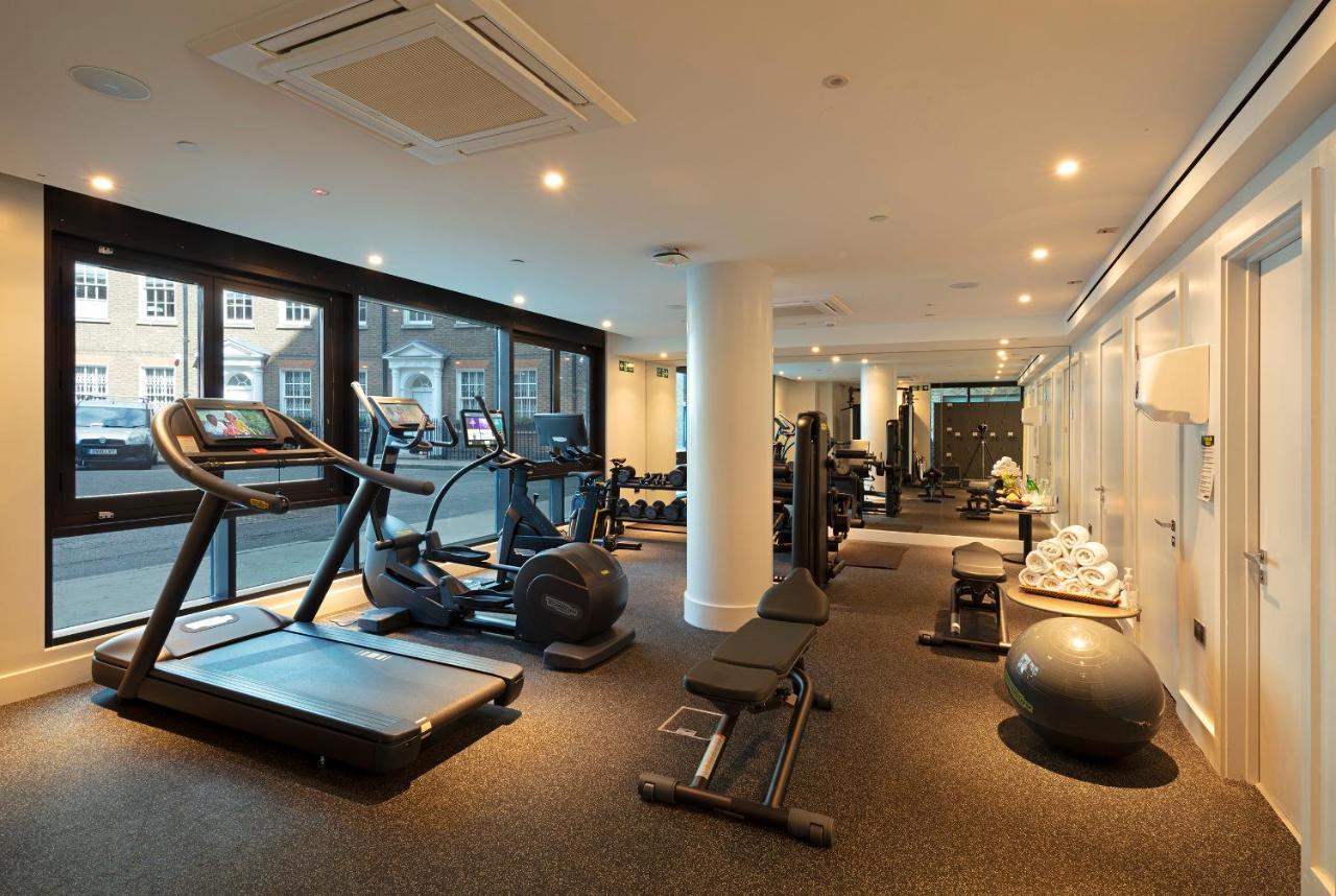 Tower Suites By Blue Orchid لندن المظهر الخارجي الصورة The photo shows a modern gym interior featuring various exercise equipment. On one side, there are several cardio machines, including treadmills and an elliptical. The gym has a spacious, bright feel with large windows allowing natural light to enter