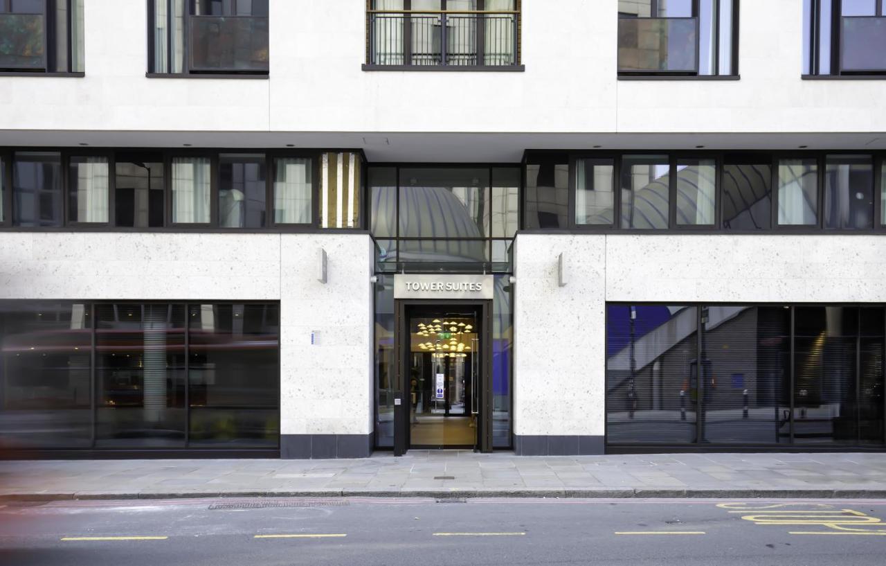Tower Suites By Blue Orchid لندن المظهر الخارجي الصورة The image shows the entrance of a modern building, characterized by its minimalist architectural design. The facade features a combination of large glass windows and smooth stone surfaces. The entrance is framed by glass doors, flanked by stylish lig
